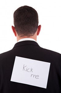 back of businessman, with kick me written in a paper