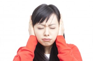 耳を塞ぐ女性