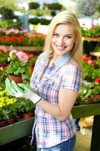 Woman shopping for and looking at plants in garden center