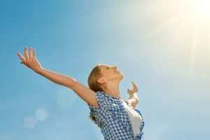 happy young woman open her arms to the sky
