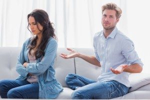 Woman with arms crossed back to her partner who is gesturing