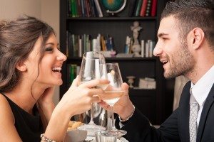 Attractive elegant young couple drinking to each others celebrat