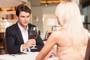 Attractive man with wine glass looking at beautiful woman.