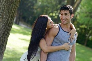 Happy smiling couple laying on green grass