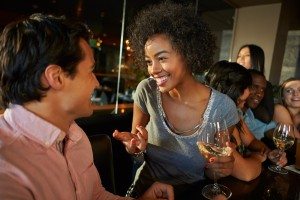 Couple Enjoying Drink At Bar With Friends