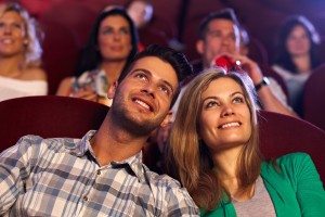 Happy couple watching movie in cinema