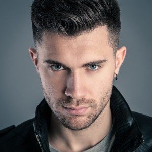 Intense man close up portrait against dark background.