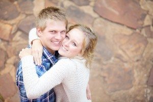 Young in-love adult couple smiling while hugging each other