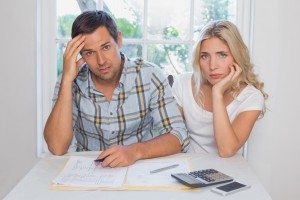 Worried couple with financial documents and calculator