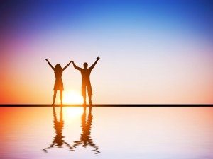 A happy couple in love standing together at sunset