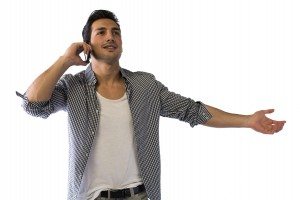 Happy young man talking on cell phone with arms open