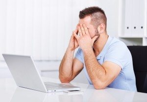Young tired businessman rubbing his eyes