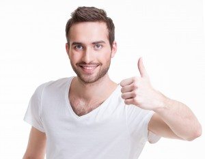 Young happy man with thumbs up sign in casuals.