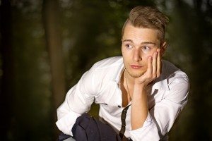 Serious young man outdoors in park at night