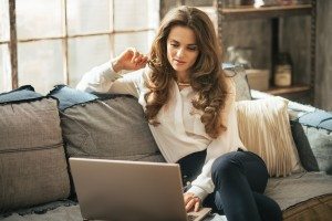 Young woman using laptop in loft apartment