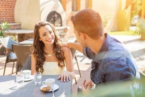 Young couple talking on the terrace of the restaurant, while eating