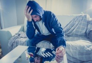 sad man doing snorting cocaine at home on his own