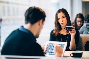 Young woman bored while boyfriend is using tablet computer in ca