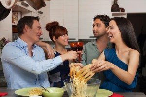 Girl serving pasta to her friends
