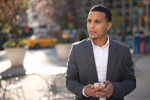 Young African American black Latino man texting cellphone