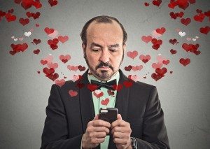 man sending love sms with mobile phone red heart flying away