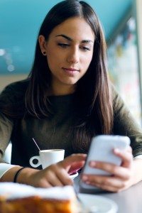 Beautiful girl using her mobile phone in cafe.