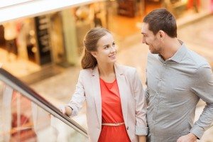 happy young couple with shopping bags in mall