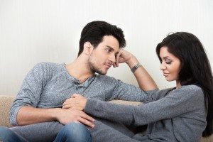 Young happy couple talking each other sitting on a sofa