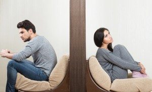 Conflict between man and woman sitting on either side of a wall