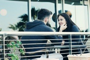 young couple relaxing together in street cafe