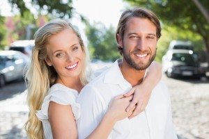 Attractive couple hugging each other and smiling at camera