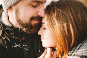 Close-up portrait of hipster couple hugging with closed eyes