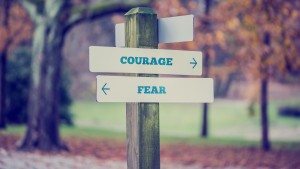 Rustic wooden sign in an autumn park with the words Courage - Fe