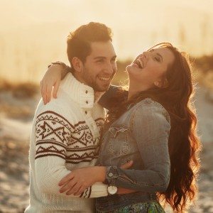 Lovely young couple on the sunset beach