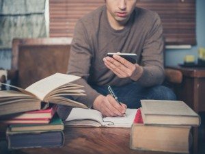 Man studying and using smart phone at home