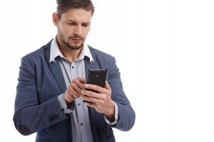 Portrait Of Happy Young Man Using Cell Phone Isolated On White B