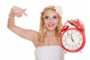 Wedding. Time to get married. Bride with alarm clock.