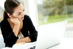 Serious young woman studying data on her laptop