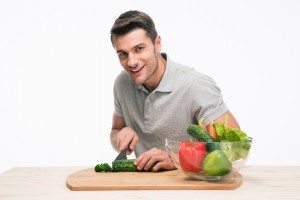 Happy man cutting vegetables