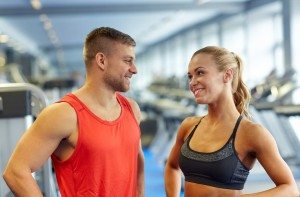 smiling man and woman talking in gym