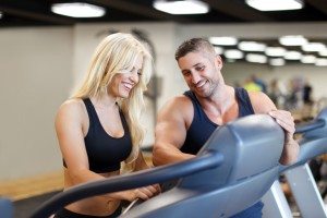 Personal trainer set difficulty on treadmill for woman