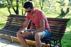 Handsome young man using his mobile phone in the street.