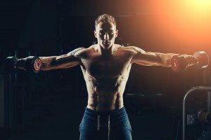 Athlete muscular bodybuilder training back with dumbbell  in the gym