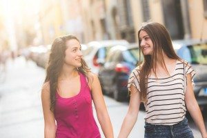 Two girls walking on the street holding hands