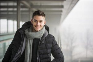 Handsome trendy man standing on a sidewalk