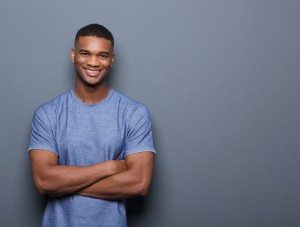 Smiling black man posing with arms crossed